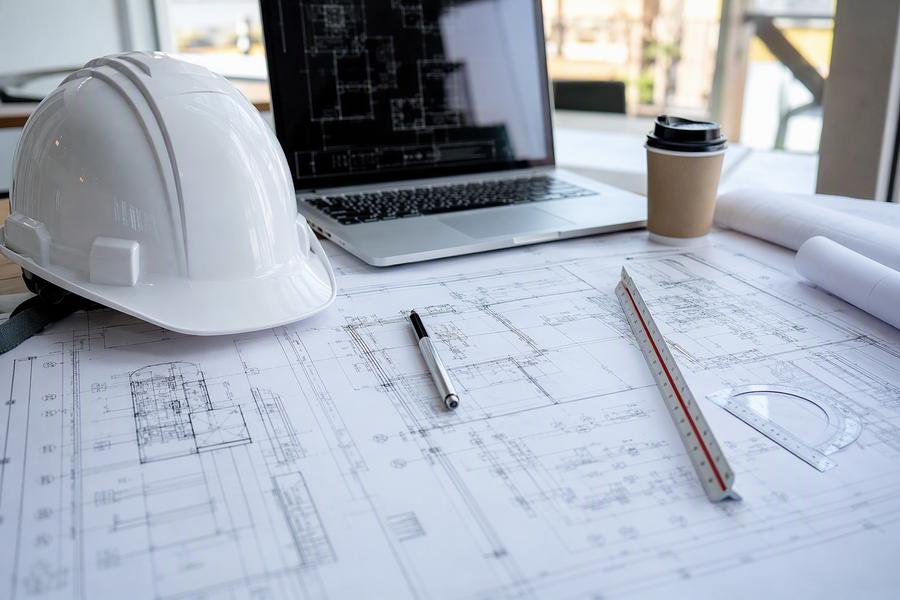 Blueprints with hard hat and laptop